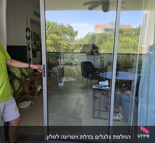 אדם פותח דלת זכוכית עם תריסים